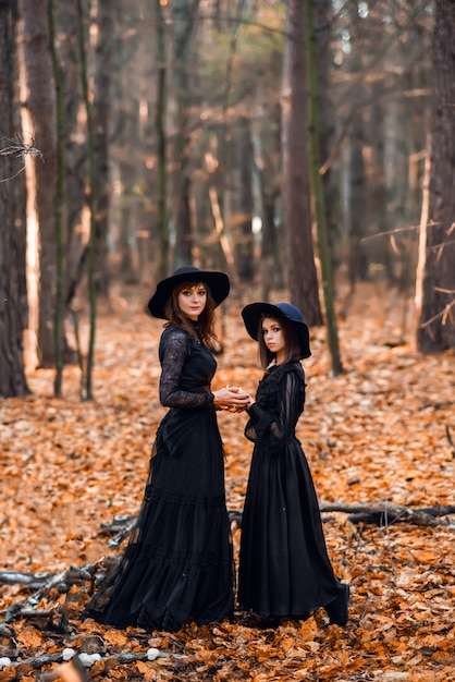 Deux sorcières dans la forêt d'automne. Mère et fille préparent une potion.