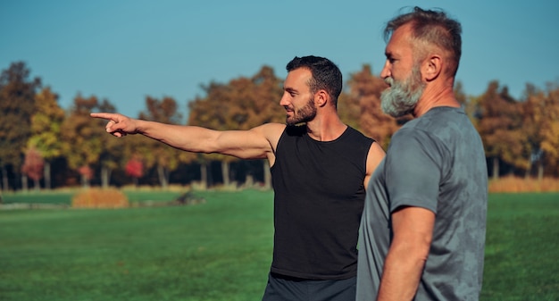 Les deux sportifs debout à l'extérieur et faisant des gestes