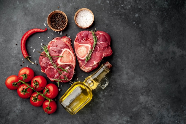 deux steaks de boeuf crus avec des os et des épices sur un fond de pierre avec copie espace pour votre texte