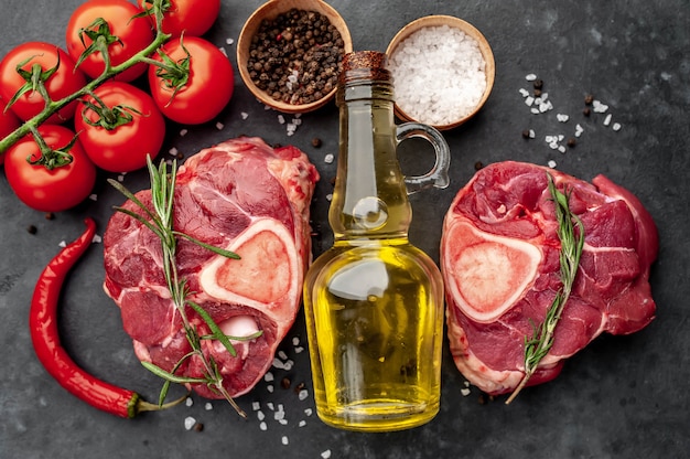 deux steaks de boeuf crus avec des os et des épices sur un fond de pierre