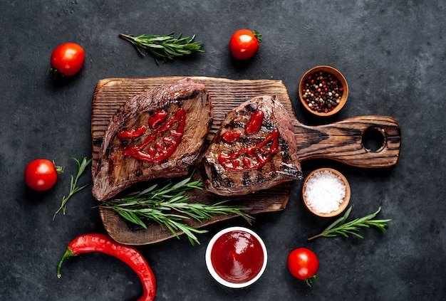 Deux steaks de monstre de boeuf grillé aux épices sur mur de pierre