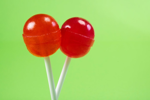 Deux sucettes sur un bâton un gros plan sur le fond vert