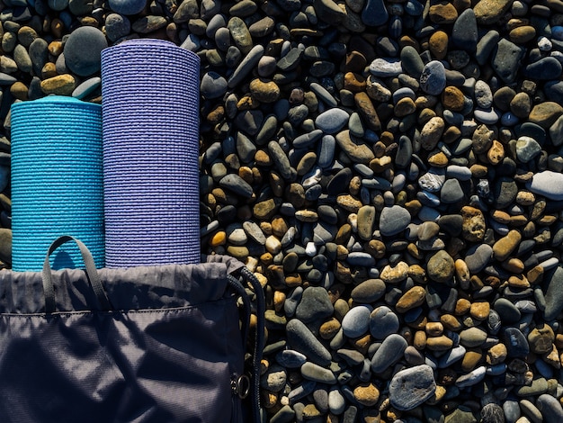 Deux tapis de yoga sur gros plan de galets de mer