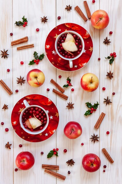 Deux tasses de boisson chaude aux fruits de Noël avec des épices et des baies