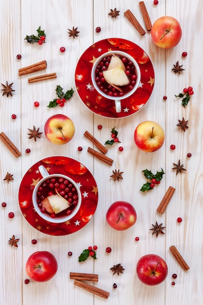 Deux tasses avec boisson chaude aux fruits de Noël avec des épices et des baies