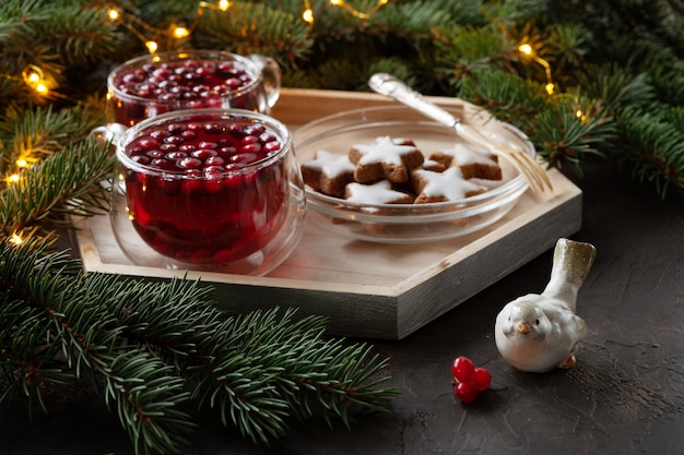Deux tasses avec boisson chaude épicée de Noël avec canneberges et gâteaux