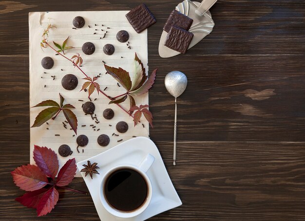 Deux tasses de café avec des biscuits avec des feuilles colorées en automne.