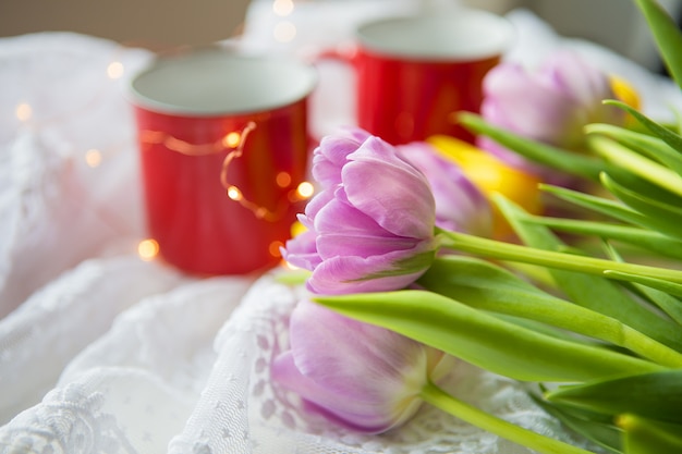 Deux tasses de café et un bouquet de tulipes lumineuses