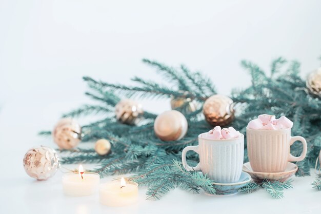 Deux tasses de café avec des branches de guimauve et de sapin de Noël