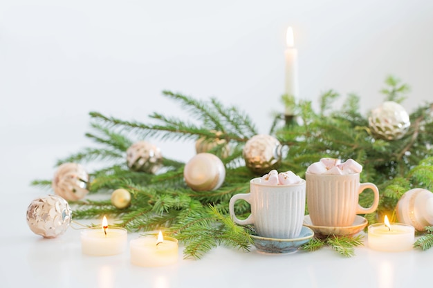 Deux tasses de café avec des branches de guimauve et de sapin de Noël