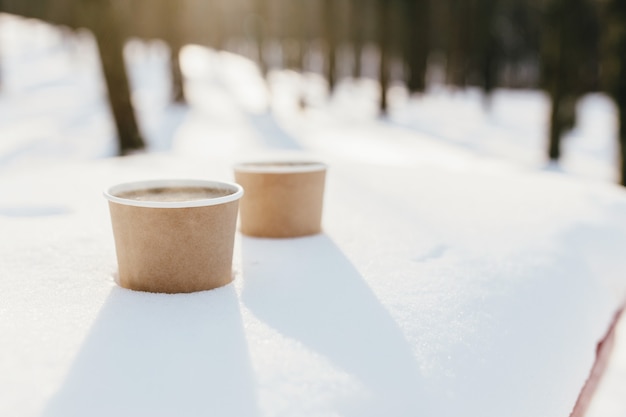 Deux tasses de café dans la neige dans la forêt