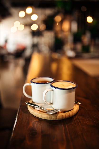 Deux tasses avec café du matin sur une planche de bois