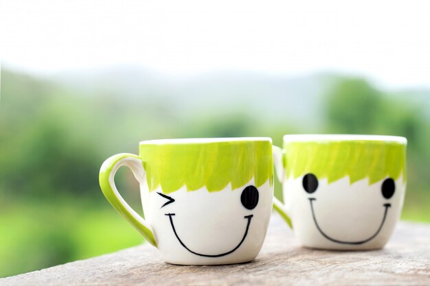 Photo deux tasses de café sur fond de bois avec du vert naturel