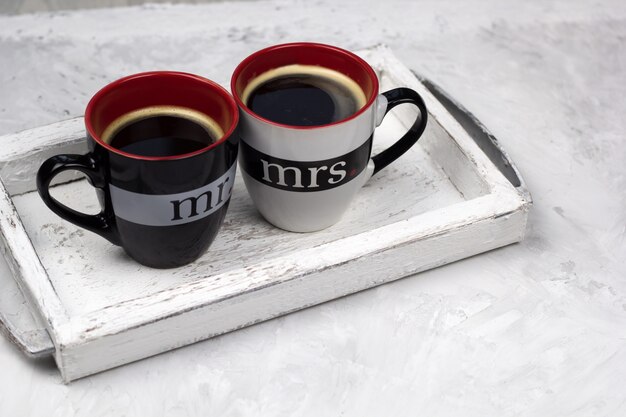 Deux tasses de café noir sur fond de béton de plateau en bois vintage