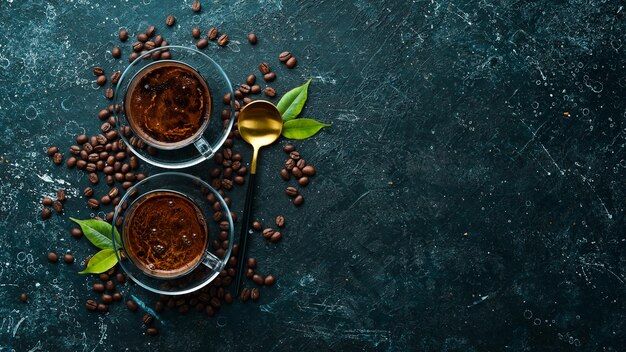 Deux tasses de café parfumé et de grains de café sur fond de pierre noire Vue de dessus Espace libre pour le texte