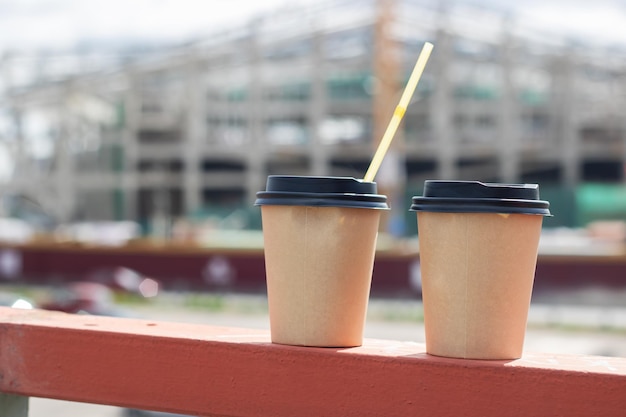 Deux tasses à café en plastique sur le fond de la ville