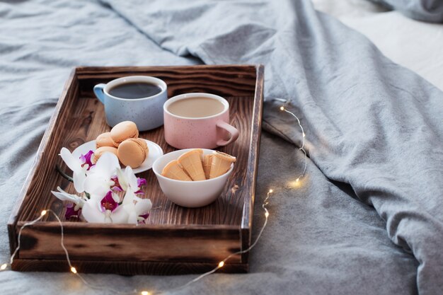 Deux tasses de café sur un plateau en bois dans la chambre