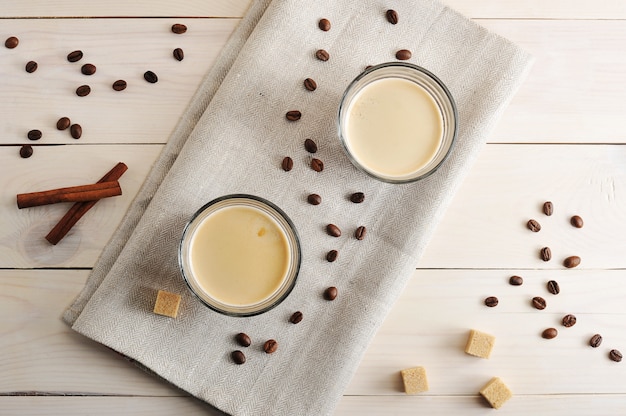 Deux tasses de café sur une serviette en lin et des grains de café avec du sucre et de la cannelle