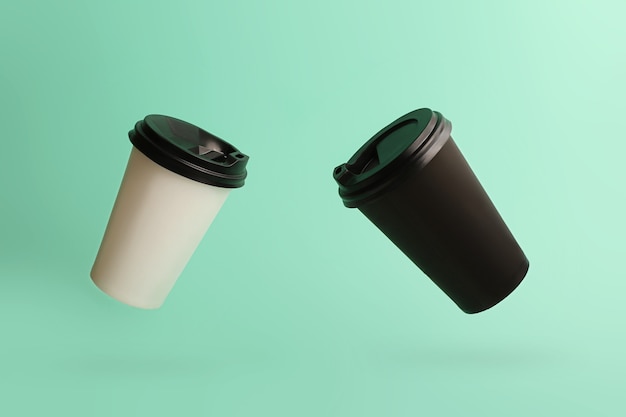 Deux tasses de café volantes sur le beau fond de menthe Noir et blanc bicolore