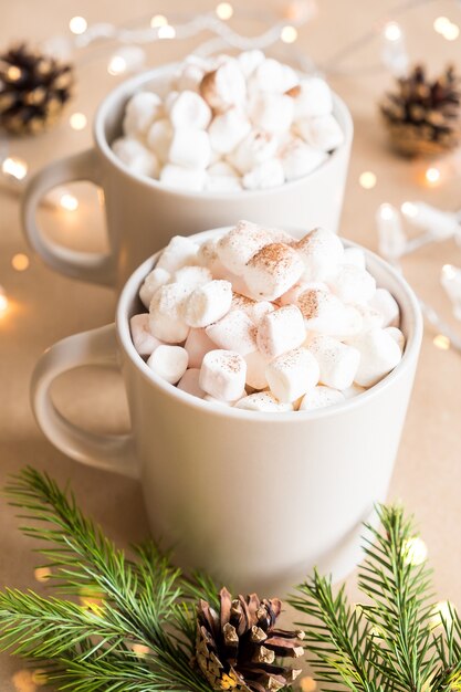 Deux tasses de chocolat chaud avec des guimauves sur table marron