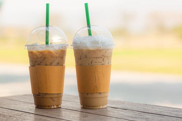 Deux tasses à emporter en plastique de café noir glacé americano et café au lait glacé sur table en bois dans le coff