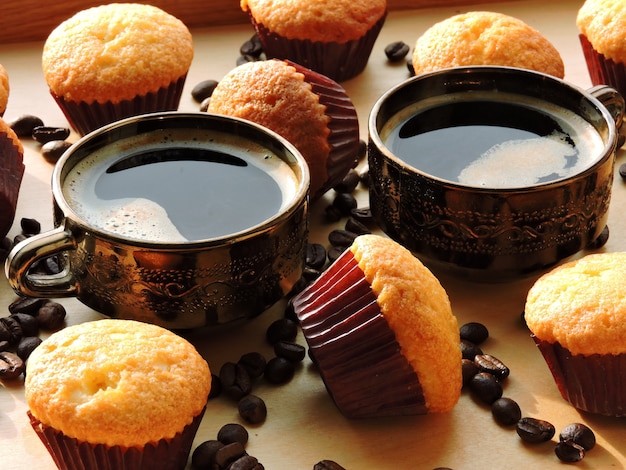 Deux tasses d'expresso, mini muffins, grains de café.