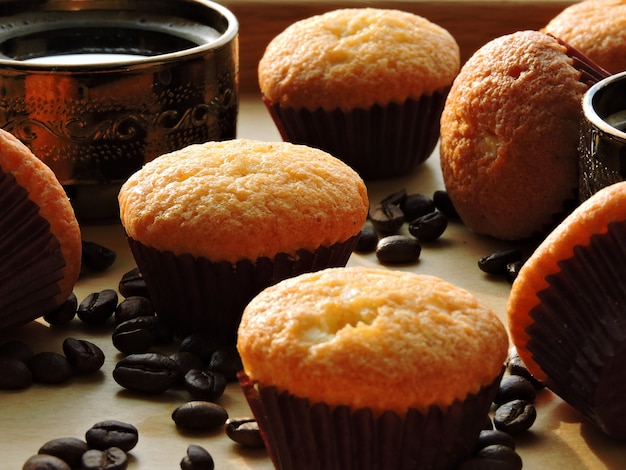 Deux tasses d'expresso, mini muffins, grains de café.
