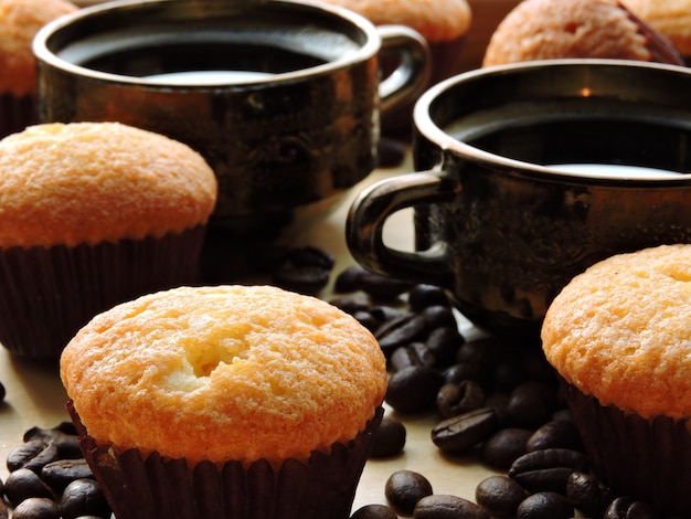 Deux tasses d'expresso, mini muffins, grains de café.