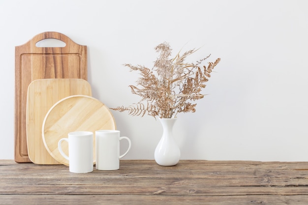 Deux tasses et fleurs séchées sur cuisine blanche