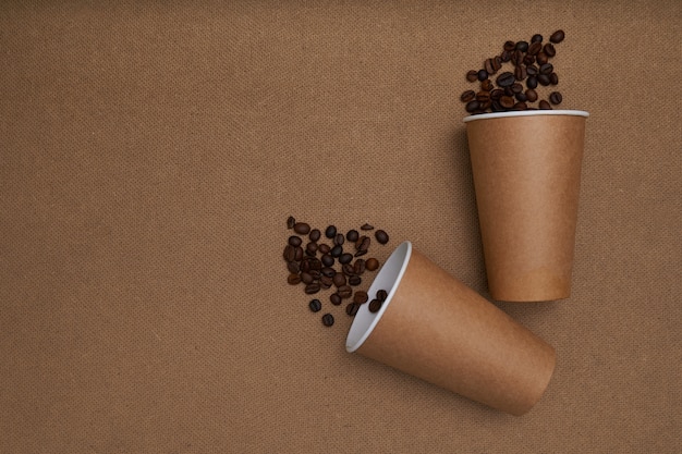 Deux tasses en papier avec des grains de café