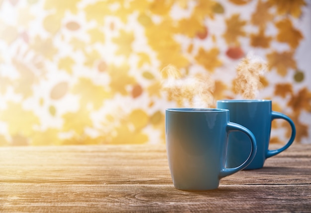 Deux tasses de tasse de café chaud sur une feuille d'automne