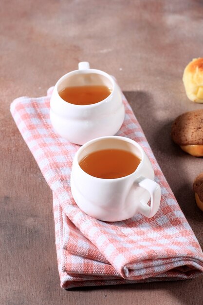 Deux tasses de thé de l'après-midi sur serviette à carreaux rose