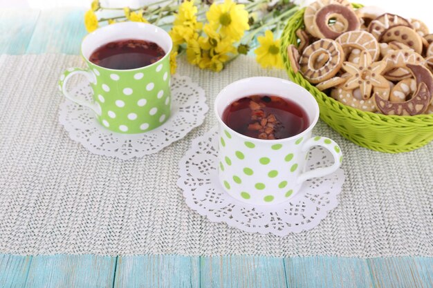 Deux tasses de thé à pointes avec des biscuits sur fond de tissu