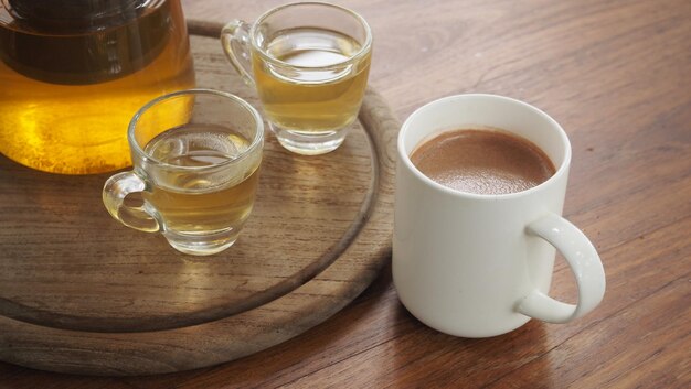 Deux tasses de thé et une tasse de chocolat chaud sur la table basse