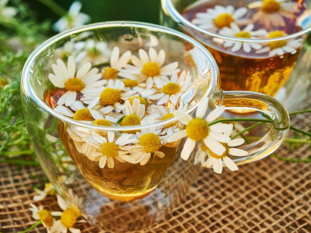 Deux tasses en verre de thé à la camomille sur un morceau de toile de jute