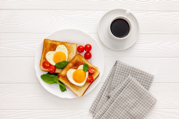 Deux toasts avec des œufs brouillés en forme de coeur sur une assiette