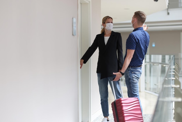 Deux touristes observent les règles sanitaires pendant la pandémie et s'enregistrent dans une chambre d'hôtel