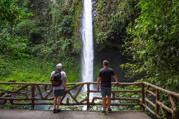 Deux touristes regardant la cascade de la fortuna au costa rica