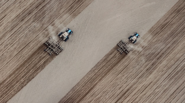 Deux tracteurs labourent le champ de la vue de dessus