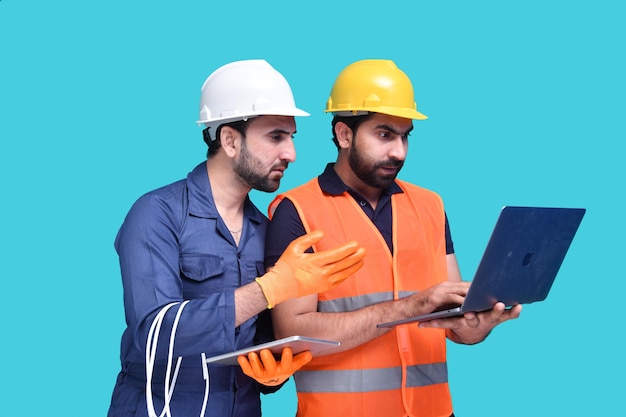 deux travailleurs de la construction à la recherche sur un ordinateur portable indien modèle pakistanais