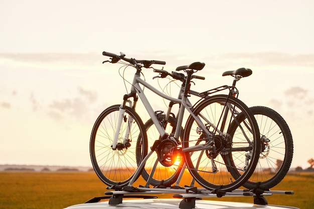 deux vélos montés sur le toit de la voiture transportant des équipements sportifs