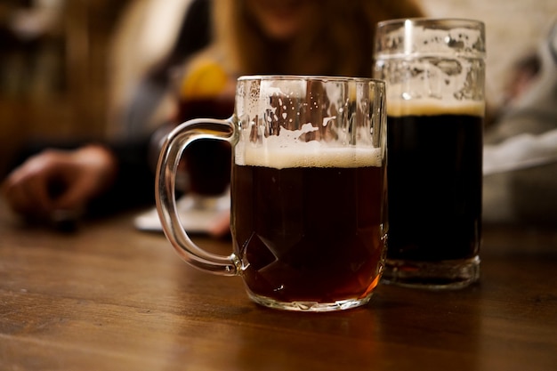 Deux Verres De Bière Brune Sur Une Table En Bois