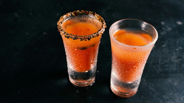 Deux verres de Bloody Mary sur une table sombre