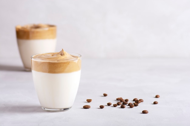 Deux verres de café Dalgona sur une table en béton gris