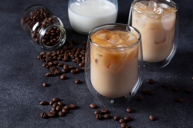 Deux verres de café froid avec du lait et des glaçons sur un fond sombre Gros plan