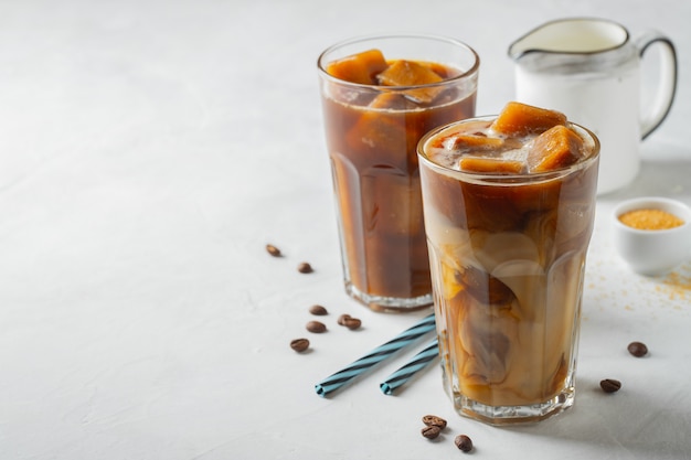 Deux verres de café froid sur fond blanc.