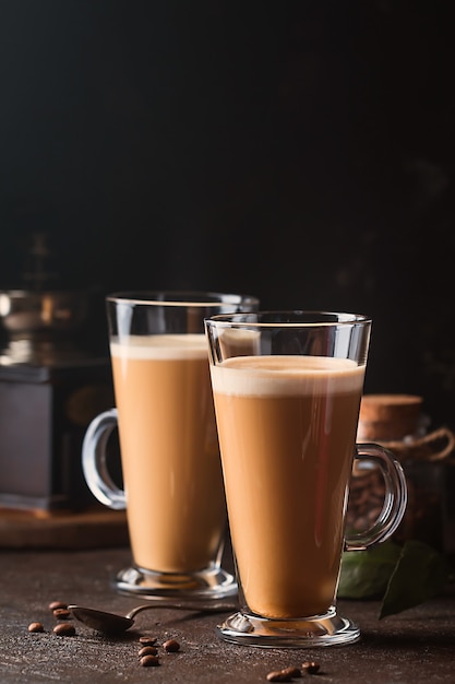 Deux verres avec café froid latte macchiato sur table contre noir