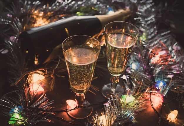 Deux verres de champagne et bouteille sur une table en bois décorée