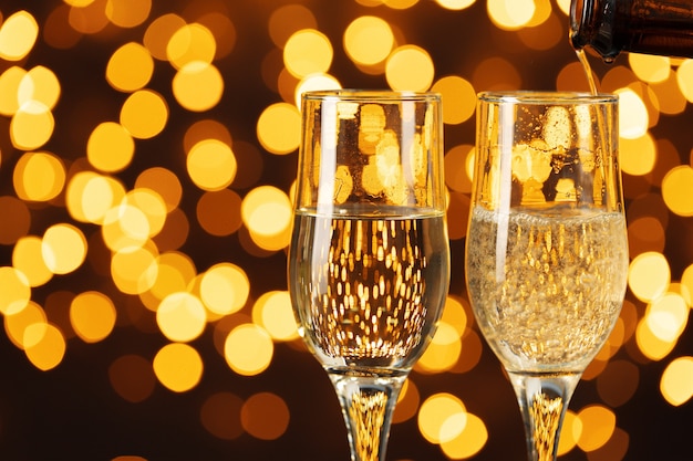 Photo deux verres de champagne contre les lumières bokeh brillantes