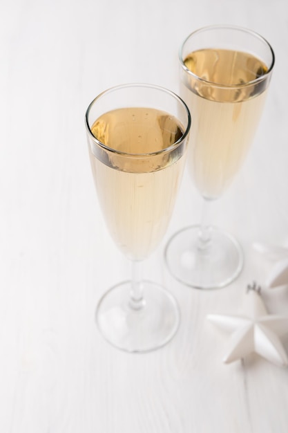 Deux verres de champagne et décorations de Noël sur fond clair. Concept de fête du nouvel an.